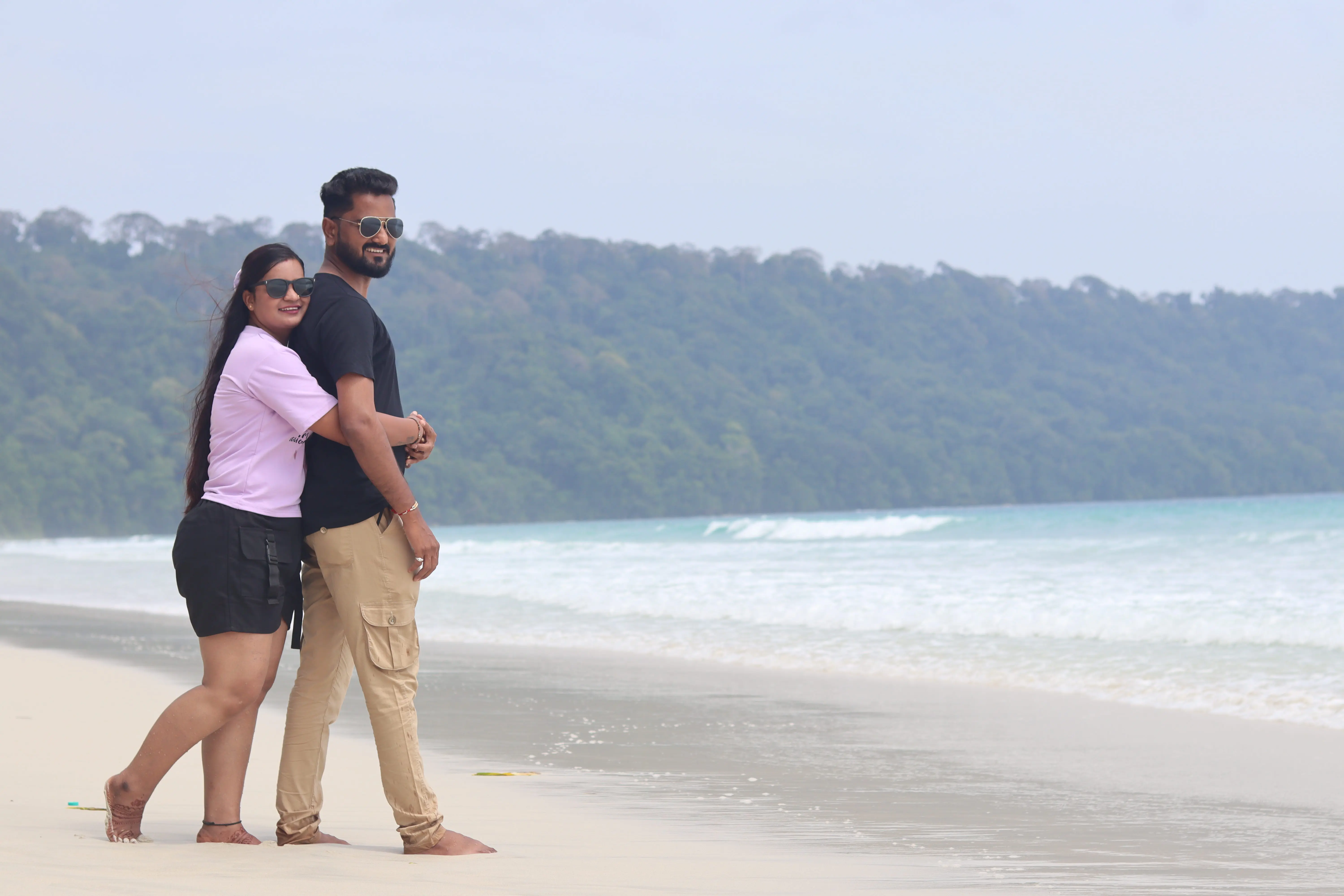 Beautiful honeymoon couple posing on Radhanagar beach, Andaman.