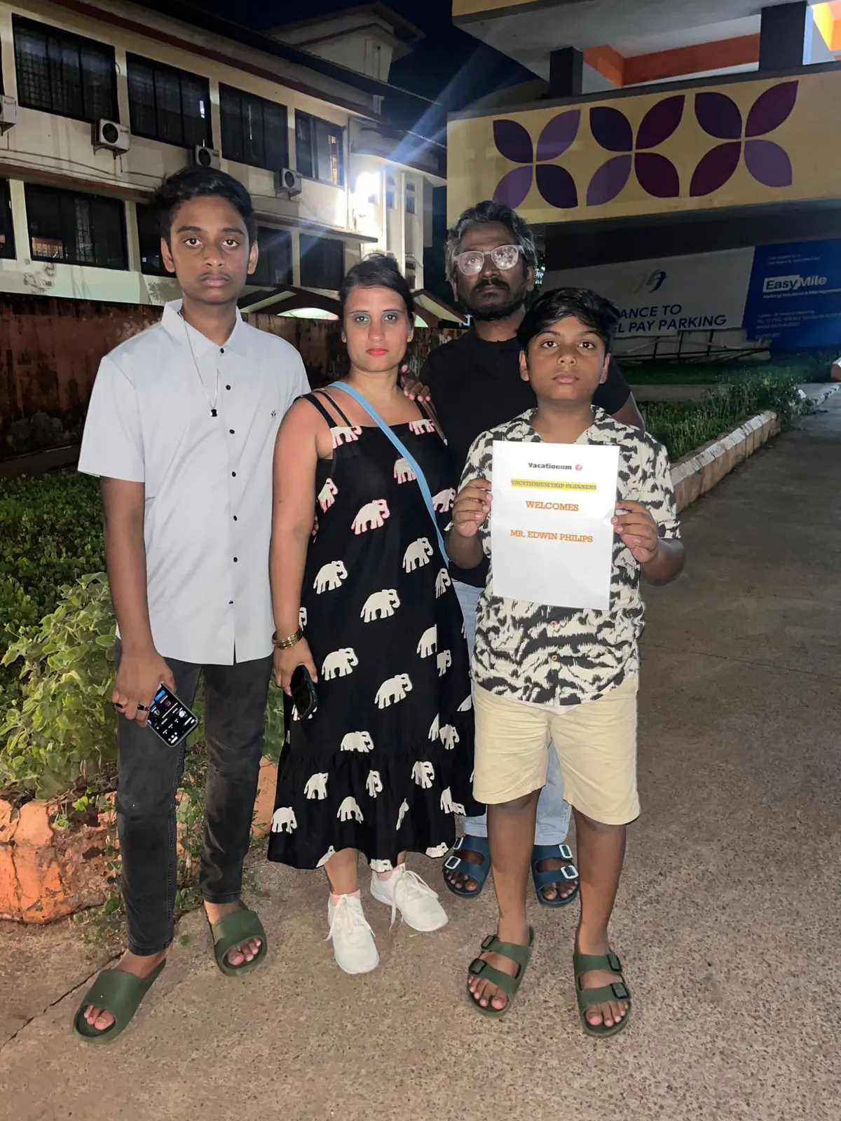 Goa airport pickup with Vacationum placard for tourists.